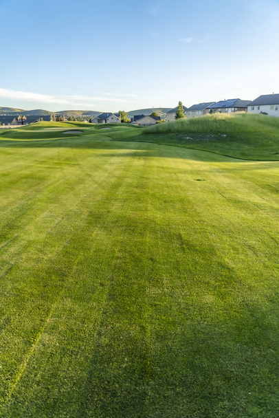Vibrant fairway of a golf course with homes and mountain in the distance - Photo, Image