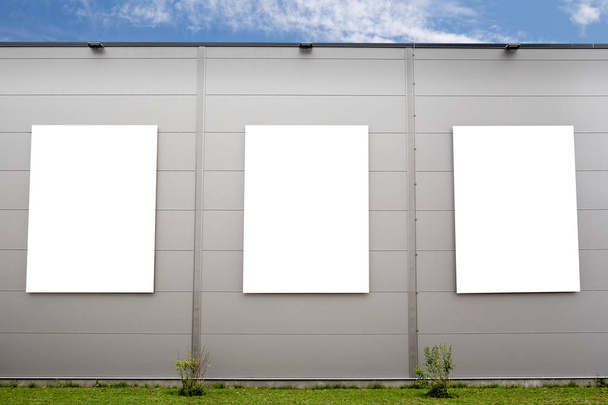 Três grandes posters verticais no edifício cinzento
 - Foto, Imagem