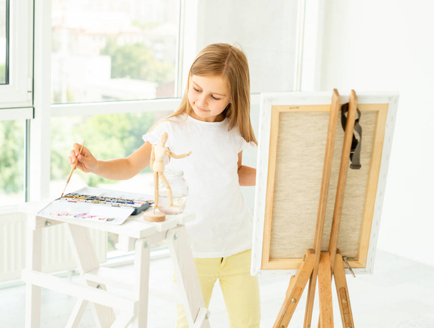 Cute little girl paints on canvas - Photo, Image