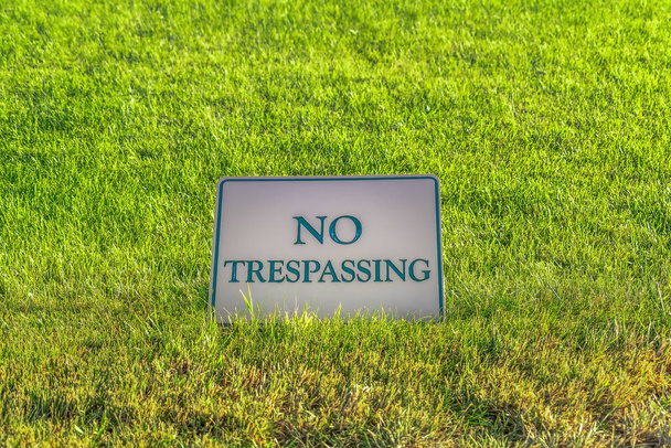 Close up of No Trespassing sign against terrain covered with vibrant grasses - Photo, Image