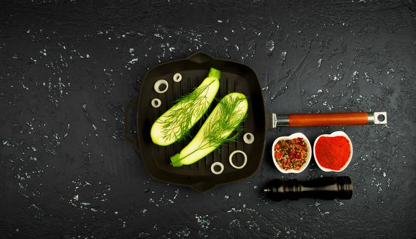 Fresh green zucchini in a pan on a dark table. The view from the top. Copy space. - Photo, image