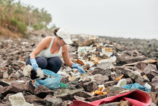 Femme aide à nettoyer le littoral des déchets en plastique
 - Photo, image