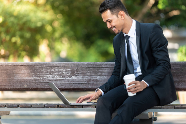 Homem de negócios malaio trabalhando em seu laptop durante sua pausa para o café
 - Foto, Imagem