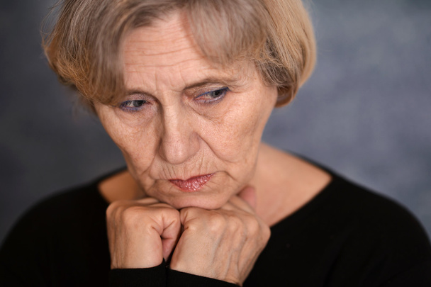 elderly woman on a gray background - Foto, imagen