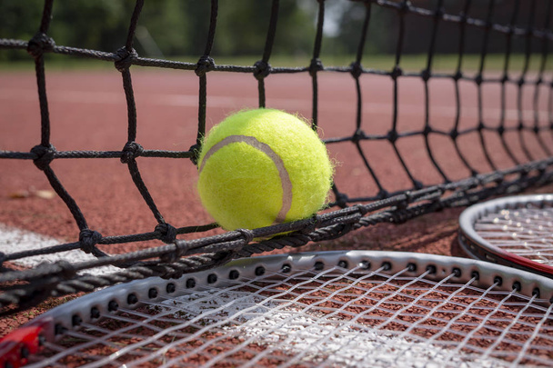 Tenisz jelenet, fekete háló, labda és teniszütők - Fotó, kép