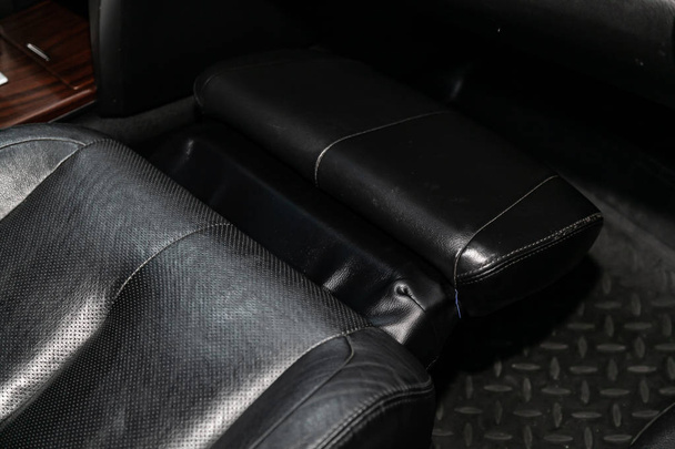 крупным планом черных кожаных задних сидений с подножьем. современный автомобиль интерио
 - Фото, изображение