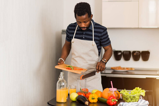 African man preparing healthy food at home in kitchen - Fotoğraf, Görsel