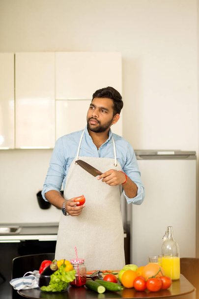 Handsome young man standing in the kitchen at home - Fotoğraf, Görsel
