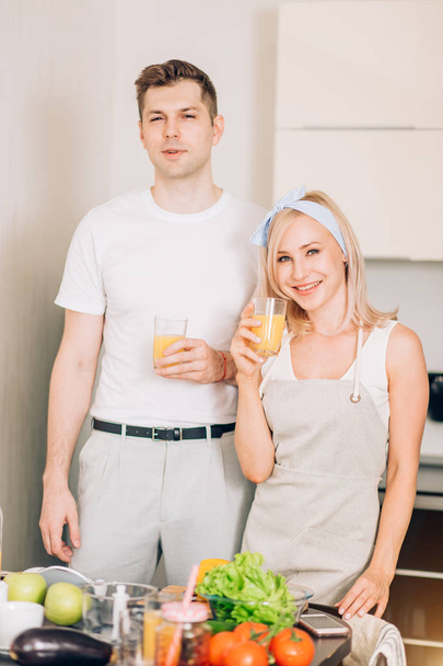 Couple making fresh organic juice in kitchen together - Photo, Image