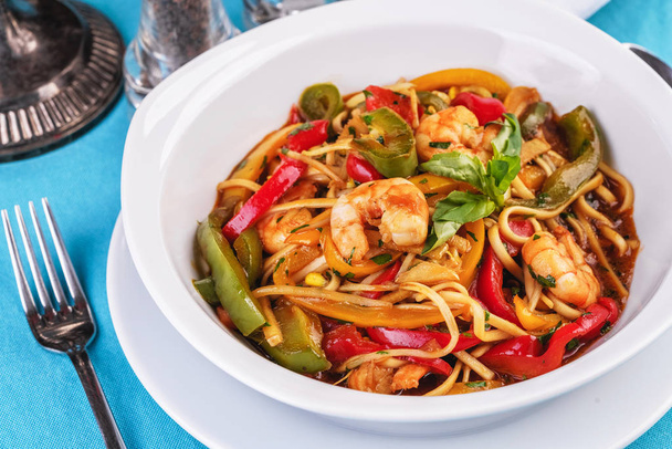 Mediterranean dish, Georgian recipe. Pasta with shrimps, red and green pepper, basil - Photo, Image