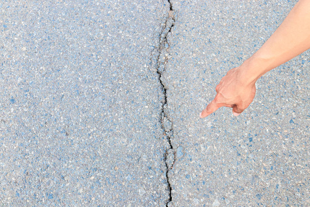χέρι δάχτυλο δείχνει επιθεωρήσει σπασμένη άσφαλτο δρόμο οδός του αυτοκινητόδρομου - Φωτογραφία, εικόνα