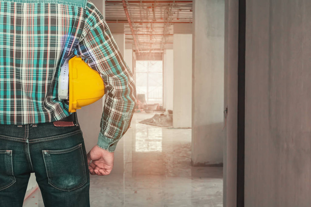 ingegneria mano tenuta casco giallo di sicurezza. controllare interni ristrutturare casa cantiere di lavoro
 - Foto, immagini