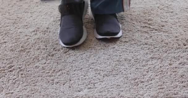 Άτομο που απογειώσουν αθλητικά παπούτσια σε μαλακό χαλί - Πλάνα, βίντεο