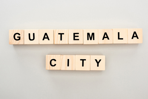 top view of wooden blocks with Guatemala city lettering on grey background - Фото, изображение