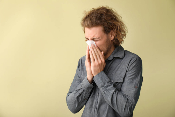 Jeune homme malade avec essuie-nez sur fond de couleur
 - Photo, image