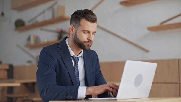 homme d'affaires en costume assis dans un café et utilisant un ordinateur portable
 - Séquence, vidéo