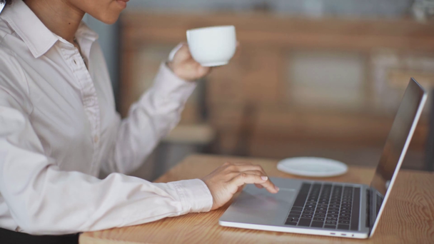 visão parcial da mulher de negócios americana africana usando laptop e beber café
 - Filmagem, Vídeo