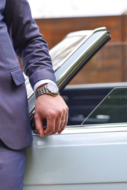 車の近くに腕時計を持つビジネスマン - 写真・画像