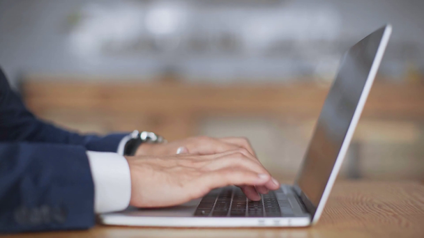 visão cortada de homem de negócios em desgaste formal usando laptop no café
 - Filmagem, Vídeo