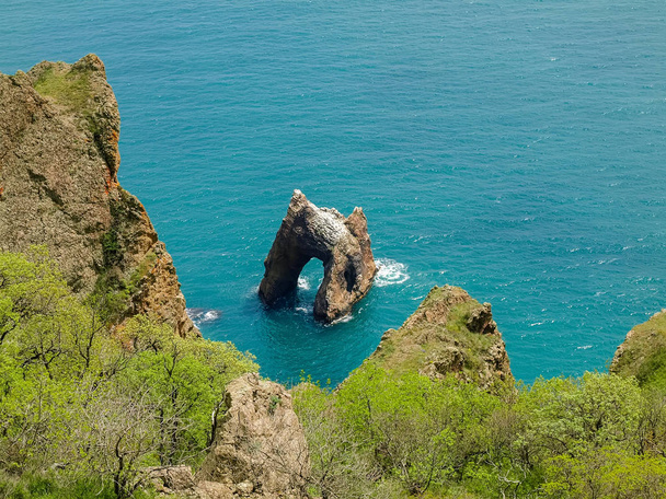 Arc rocheux d'origine volcanique près du bord de mer
  - Photo, image