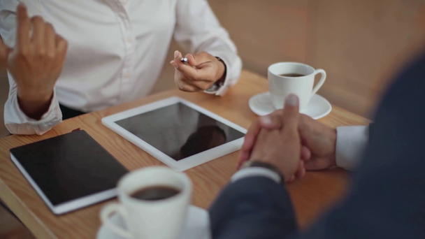 μια περικομμένη θέα των πολυπολιτισμικών επιχειρηματικών εταίρων που κάνουν χειραψία στο καφέ και φεύγουν - Πλάνα, βίντεο