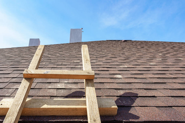 Asphalt tile roof with ladder on new home under construction - Photo, Image