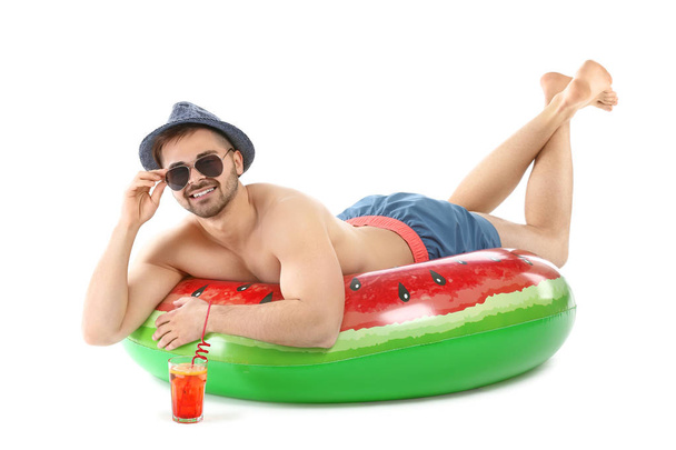 Happy young man with inflatable ring and cocktail on white background - Fotó, kép