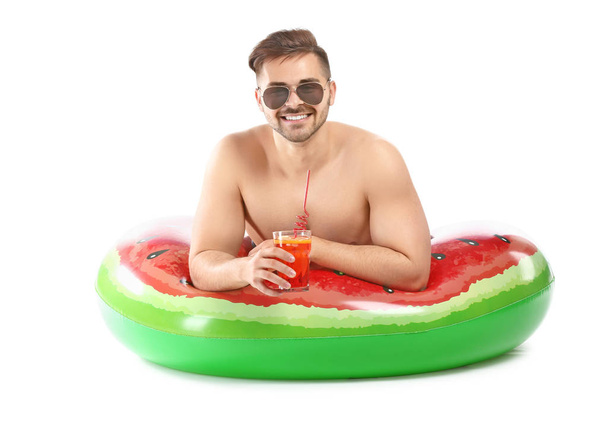 Happy young man with inflatable ring and cocktail on white background - Foto, afbeelding