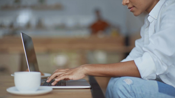 vista cortada da mulher de negócios afro-americana digitando no laptop n café
 - Filmagem, Vídeo