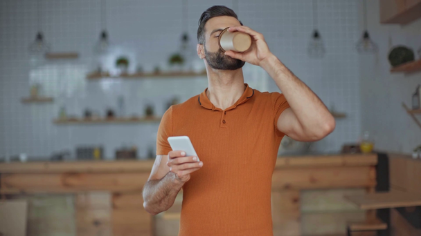 smiling hipster using smartphone, drinking coffee in cafe - Footage, Video