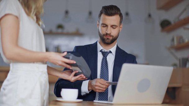 uomo d'affari con computer portatile con carta di credito e terminale per il pagamento nel caffè
 - Filmati, video