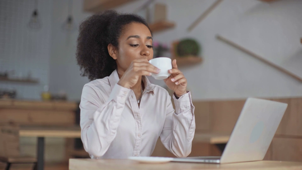 African American biznesmen za pomocą laptopa, picie kawy w kawiarni - Materiał filmowy, wideo