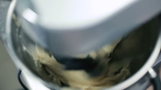 Combine off. The dough is no longer stirred. Cook picks up the bowl with agitator. Combine agitator begins to mix the dough in a bowl. Man includes processor. The camera is a major dough of stirring up. Close-up. - Footage, Video