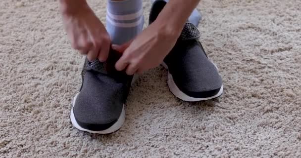 Person puting on sneakers on soft carpet - Footage, Video