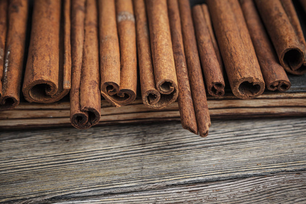 Cinnamon sticks on wooden background. - Foto, imagen