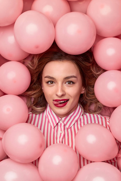 Stylish woman in balloons showing tongue - Zdjęcie, obraz