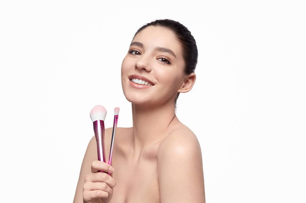 Smiling woman with makeup brushes - Foto, immagini