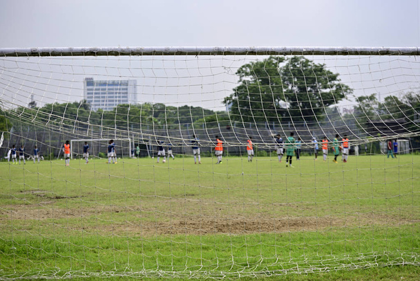 Campo de futebol vazio em um complexo esportivo, Imagem é capturada por trás de gol de futebol
. - Foto, Imagem