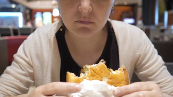 Mulher comendo batatas fritas e hambúrguer no restaurante fast food, boca close-up
. - Filmagem, Vídeo