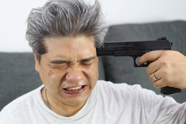 Stary człowiek z białymi włosami postanowił pójść popełnić samobójstwo przez pistolet - Zdjęcie, obraz