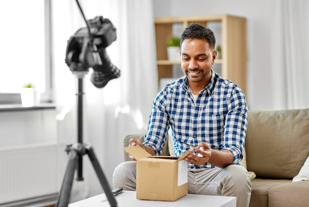 male video blogger opening parcel box at home - Foto, Imagem