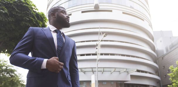 Selbstbewusster schwarzer Geschäftsmann vor modernem Bürocenter-Hintergrund - Foto, Bild
