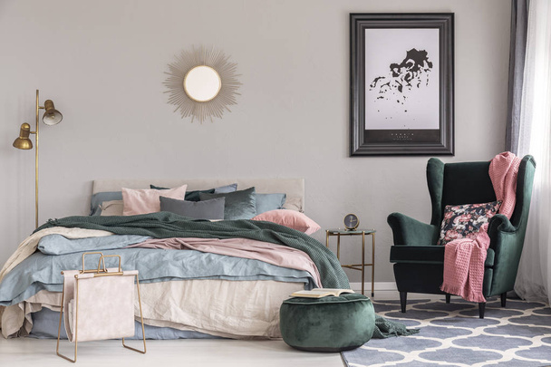 Emerald vihreä nojatuoli kukka tyyny ja pastelli vaaleanpunainen huopa trendikäs makuuhuone sisustus
 - Valokuva, kuva