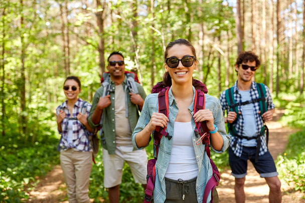 friends with backpacks on hike in forest - Zdjęcie, obraz