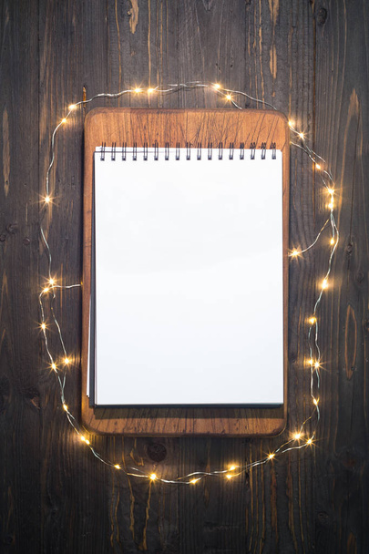 Cuaderno en blanco, rodeado de pequeñas luces, ideal para maqueta
 - Foto, Imagen