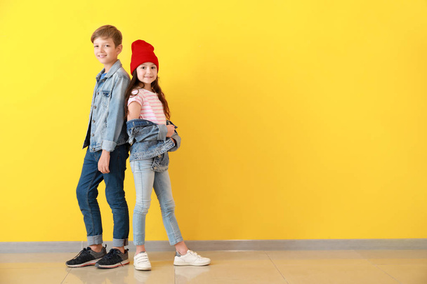 Stylish children in jeans clothes near color wall - Photo, Image