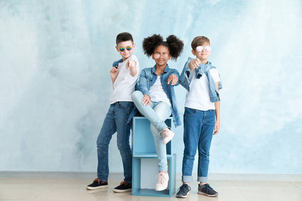 Stijlvolle kinderen in jeans kleding in de buurt van Color Wall - Foto, afbeelding