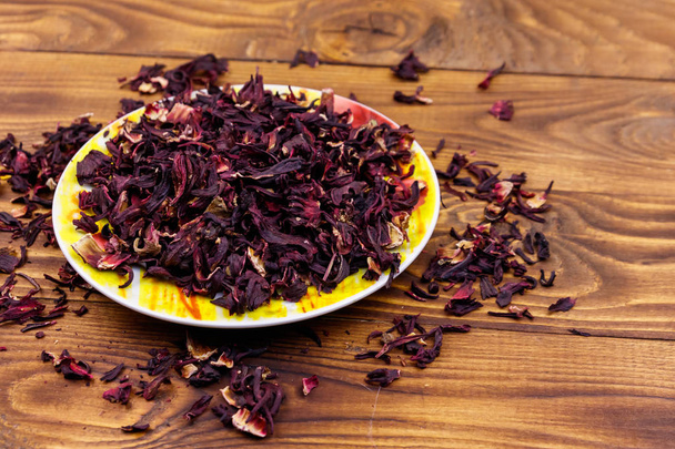Dried hibiscus (carcade, roselle) on wooden table - Foto, imagen