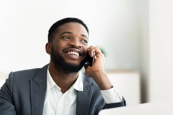 Örülök, hogy afrikai üzletember beszél telefonon az irodában. - Fotó, kép