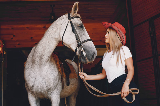 Elegant girl in a farm wiith a horse - Φωτογραφία, εικόνα